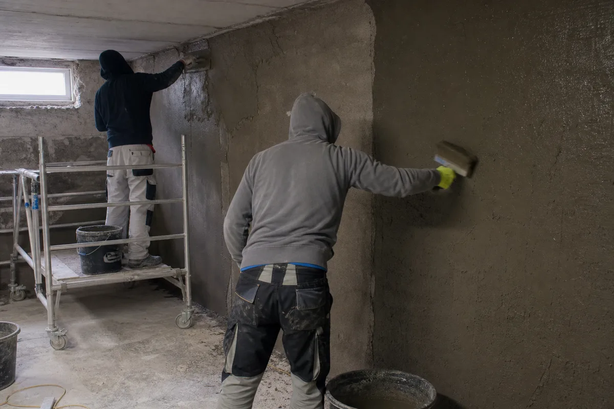 Aplikácia sanačnej omietky a hydroizolácie na stenu suterénu